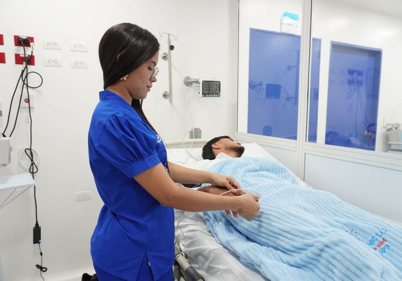 Enfermera acompaña a un paciente en cama durante el cuidado hospitalario