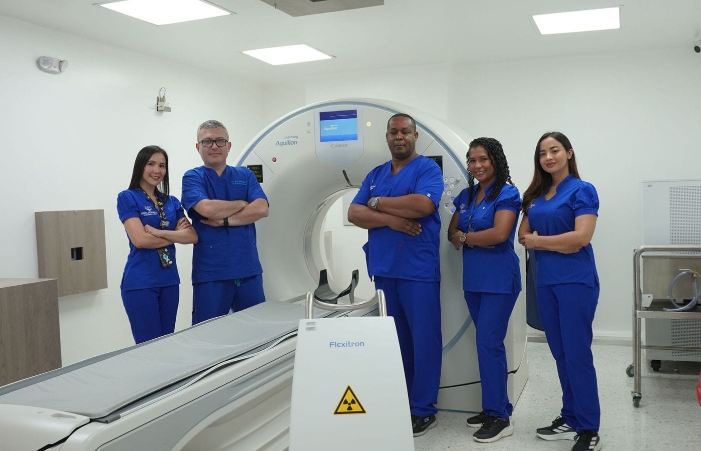 Equipo de imagenología junto al tomógrafo Canon Aquilion y el sistema Flexitron